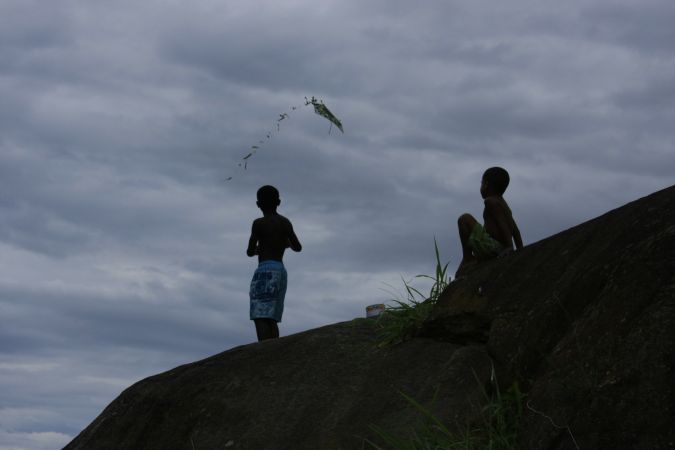 Foto em alto contraste de duas crianças soltando pipa no alto do morro (Sônia Fleury)