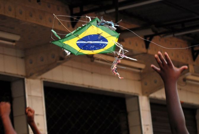 Foto da mão de uma criança e uma pipa com a estampa da bandeira do Brasil (Bira Carvalho)