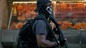 Policial no Jacarezinho durante a ocupação do dia 19 de janeiro de 2022 com o rosto coberto e um fuzil na mão. Foto: Carl de Souza/AFP