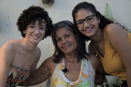 Foto da moradora Jane ao centro, ao seu lado esquerdo a entrevistadora Débora e ao seu lado direito a entrevistadora Juliana.