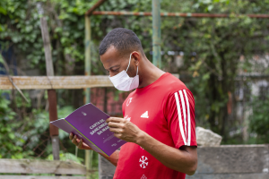 Morador com a carta de saneamento da Maré, publicação que reúne dados do Cocôzap. Foto Patrick Marinho-Data Labe.png